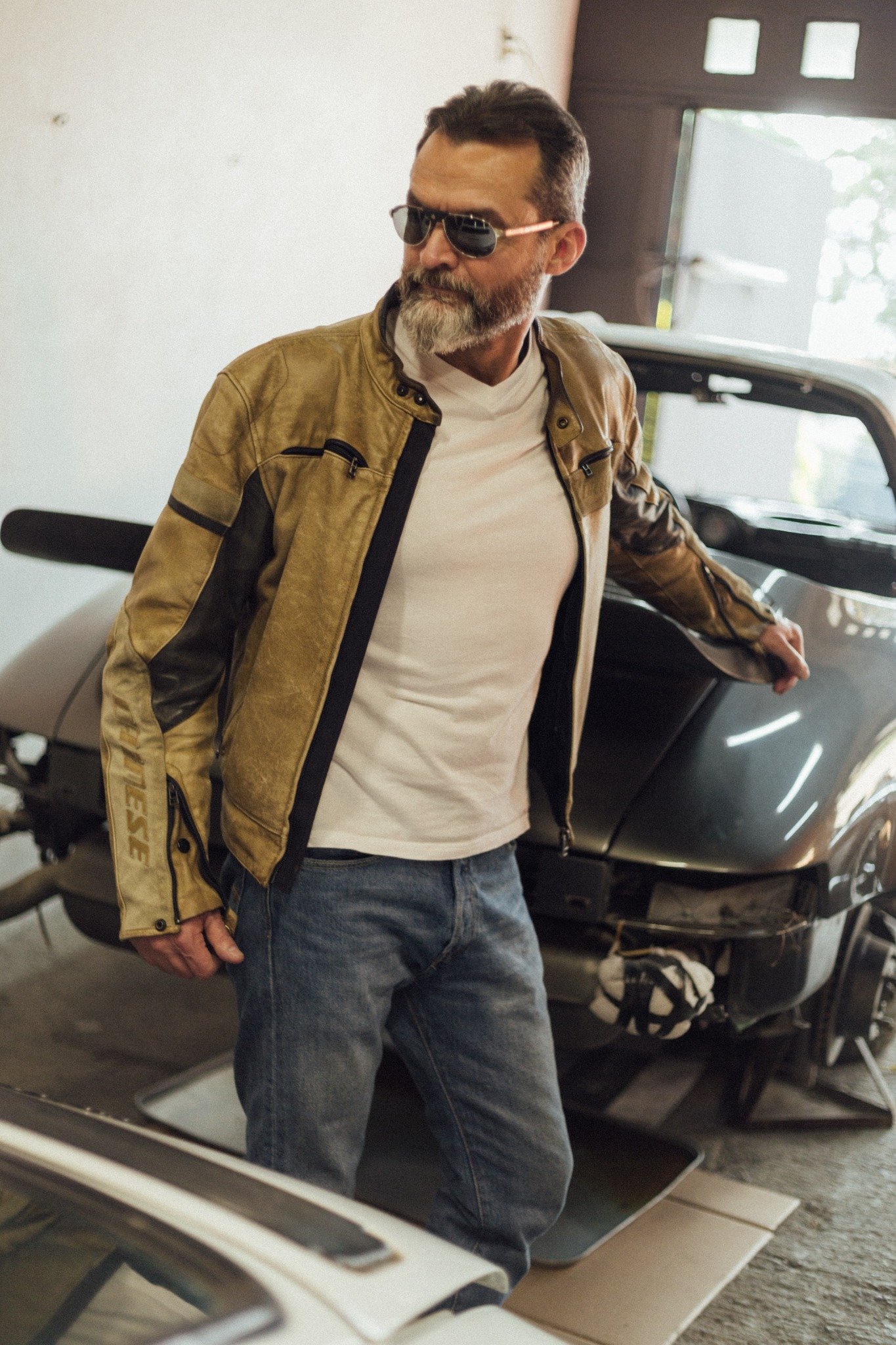 Gildo Bo wearing a jacket in an automotive garage